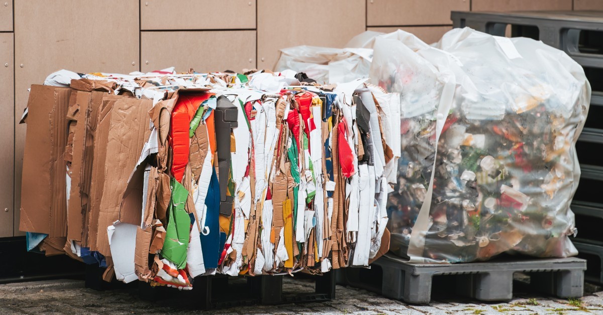 A pile of discarded waste being moved from a stack into a bag on a pallet ready to be properly destroyed.
