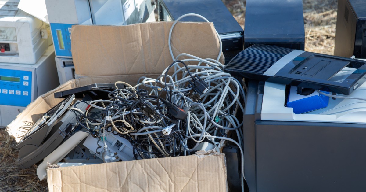 A pile of old electronics sitting outdoors ready to be discarded for proper waste collection and disposal.