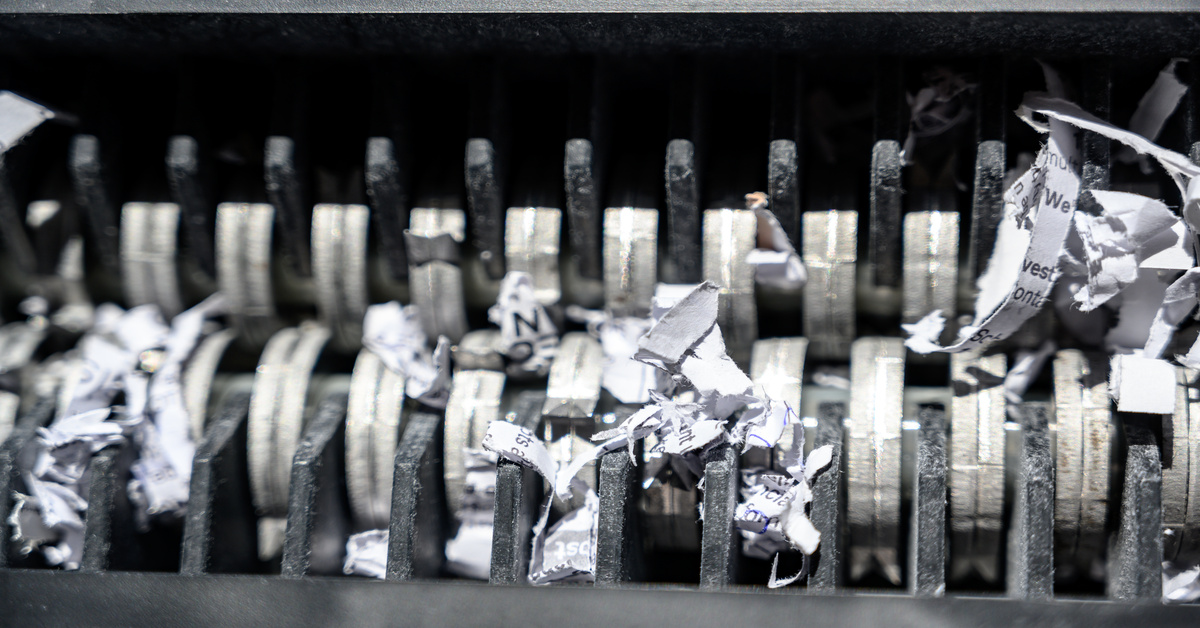A closeup of the teeth on a mobile shredding machine as it moves bits of paper through and shreds them to pieces.