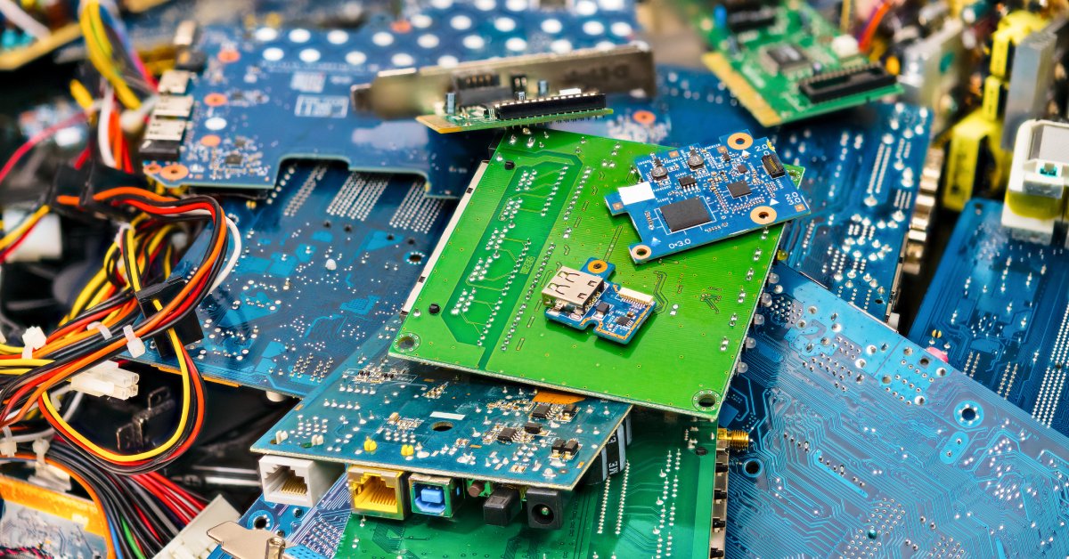 A pile of electronic parts that include large circuit boards, thin wires, and smaller components in many colors.