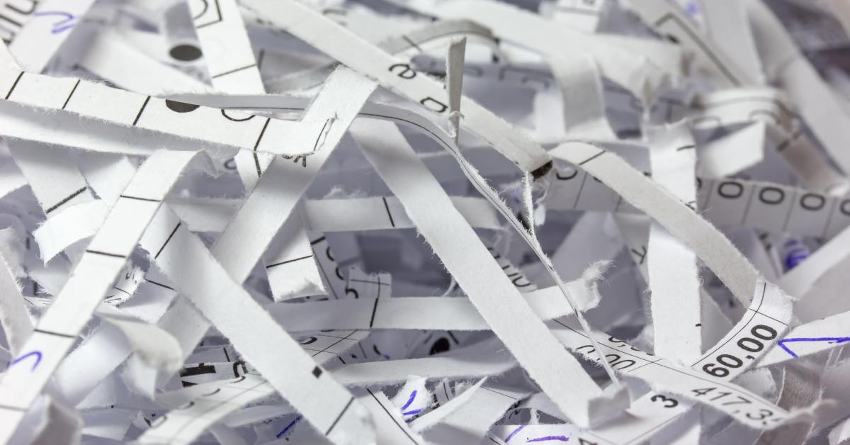 Shredded accounting and tax documents with only a few visible, legible numbers and dates remaining.