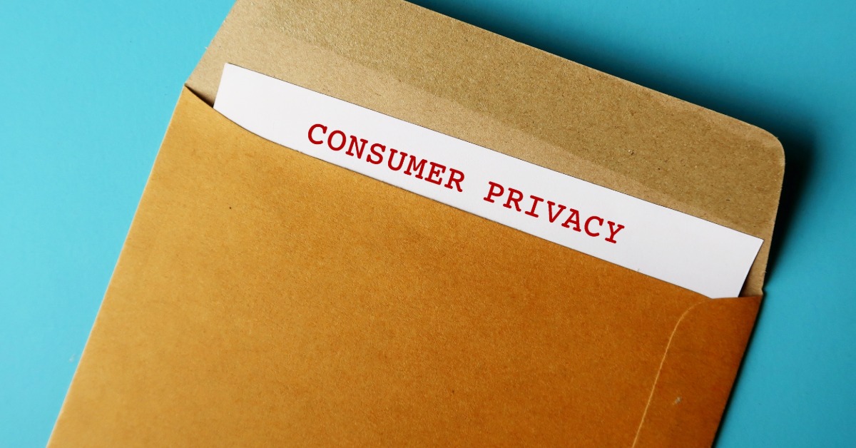 An envelope sitting on a blue surface. The envelope contains a partially visible paper reading "Consumer Privacy".