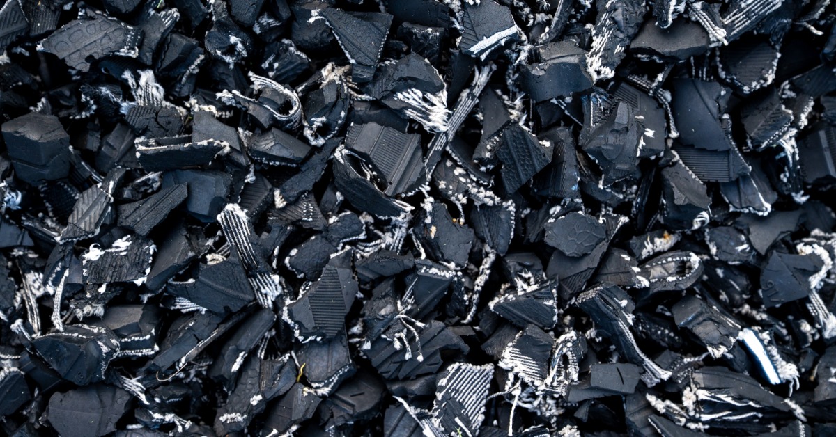A pile of shredded black rubber pieces with streaky white interiors clumped together after being torn apart.