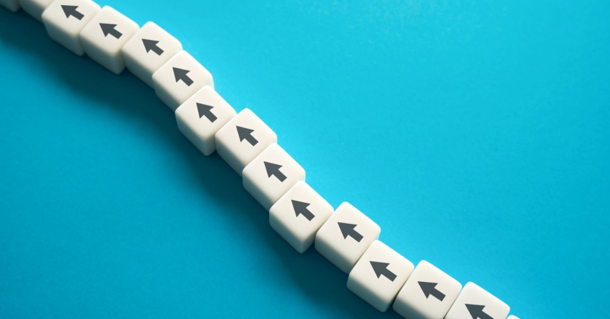 A diagonal row of blocks with arrow symbols snakes across a blue background. The arrows point in the same direction.